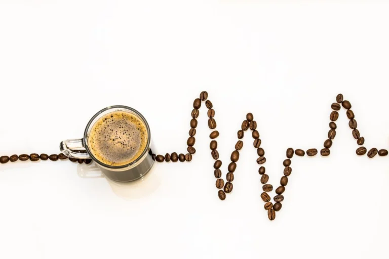 Taza de café y granos, cuanta cafeína se puede tomar al día